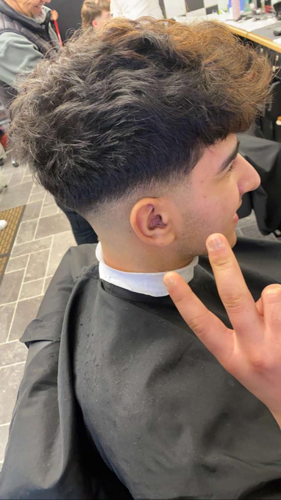 Black hair boy buzzing after his new hair cut making signs at the camera