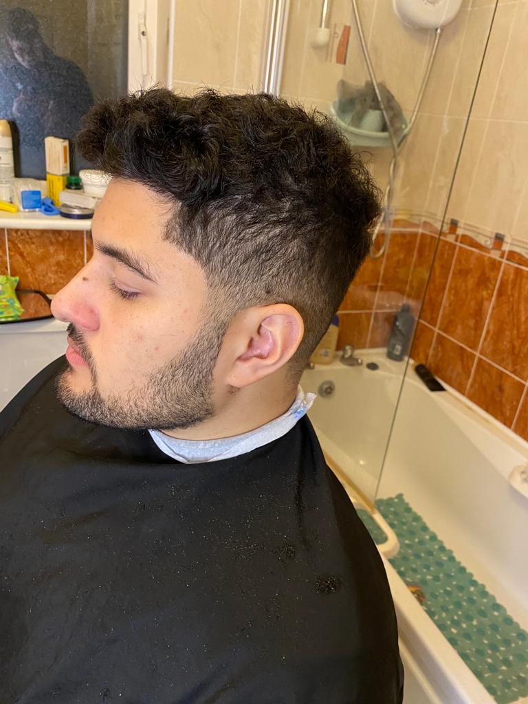 Handsome man sat in bathroom after getting haircut looking very nice